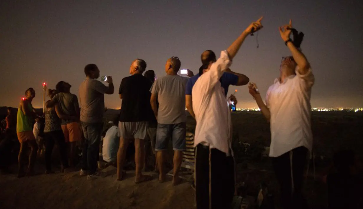 Beberapa diantara mereka asyik mengabadikan roket-roket yang menghantam kota Gaza dengan kamera handphone mereka (AFP Photo/JACK GUEZ)
