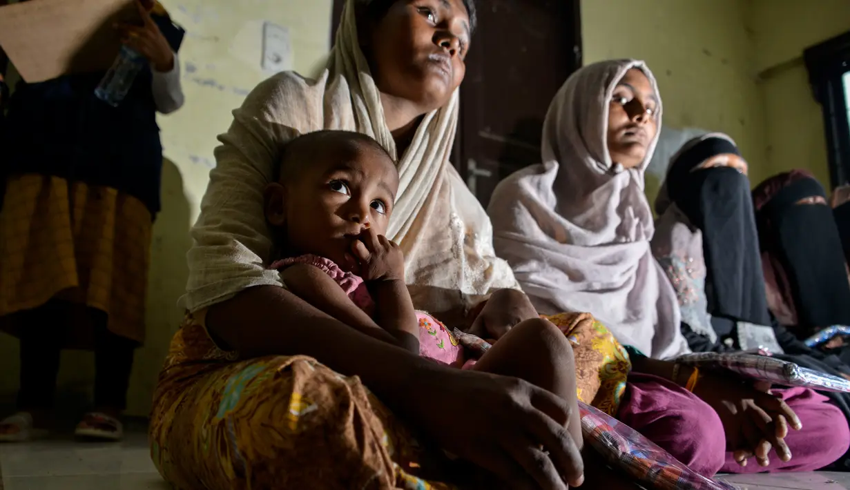 Pengungsi Rohingya menunggu di pusat penampungan sementara bekas kantor Imigrasi Punteuet di Lhokseumawe, Aceh Utara (26/6/2020). Dari hasil tes tersebut, mereka semua dinyatakan non reaktif. (AFP Photo/CHAIDEER MAHYUDDIN)