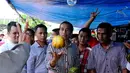 Di pasar Kebayoran Lama, Jokowi yang mengenakan kemeja kotak-kotak mengunjungi lapak pedagang buah blewah, Jakarta, Senin (30/6/14). (Liputan6.com/Andrian M Tunay)