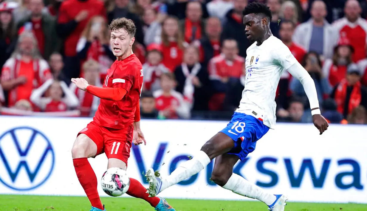 Pemain Denmark Andreas Skov Olsen (kiri) berebut bola dengan pemain Prancis Benoit Badiashile pada pertandingan sepak bola UEFA Nations League di Parken Stadium, Kopenhagen, Denmark, 25 September 2022. Denmark mengalahkan Prancis dengan skor 2-0. (Liselotte Sabroe/Ritzau Scanpix via AP)