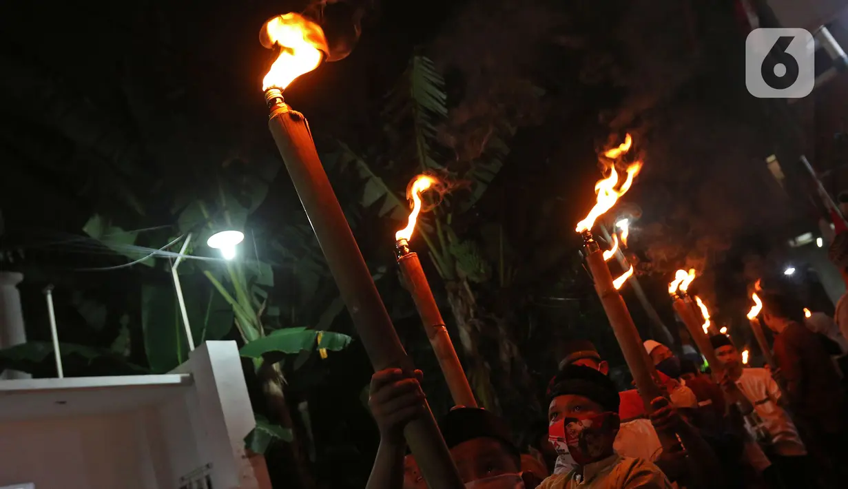Sejumlah warga saat melakukan pawai obor di Kawasan Rempoa, Tangerang Selatan, Rabu (19/08/2020). Pawai obor tersebut dilakukan dalam rangka menyambut peringatan tahun baru Islam 1 Muharram 1442 H. (Liputan6.com/Herman Zakharia)