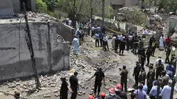 Petugas polisi, penyelidik, dan petugas penyelamat berkumpul di lokasi ledakan, di Lahore, Pakistan, Rabu (23/6/2021).  Saksi mata mengatakan intensitas ledakan itu sedemikian rupa sehingga jendela kaca rumah dan bangunan di dekatnya pecah.  (AFP/Arif Ali)