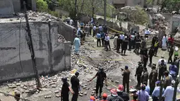 Petugas polisi, penyelidik, dan petugas penyelamat berkumpul di lokasi ledakan, di Lahore, Pakistan, Rabu (23/6/2021).  Saksi mata mengatakan intensitas ledakan itu sedemikian rupa sehingga jendela kaca rumah dan bangunan di dekatnya pecah.  (AFP/Arif Ali)