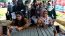 Petugas memfoto warga penerima manfaat saat penyaluran bantuan langsung tunai (BLT) Kemensos di Kecamatan Ciseeng, Bogor, Jawa Barat, Senin (28/11/2022). Setiap Keluarga Penerima Manfaat (KPM) mendapat BLT BBM sebesar Rp300ribu, Sembako Rp600 ribu dan bantuan PKH (Program Keluarga Harapan) sebesar Rp600 ribu. (merdeka.com/Arie Basuki)