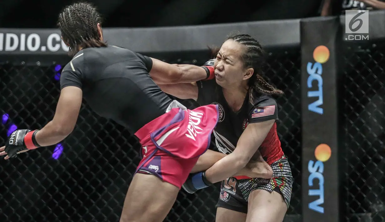 Petarung putri Indonesia, Priscilla Hertati Lumban Gaol (kiri) melakukan tendangan ke petarung putri Malaysia, Audreylaura Boniface (kanan) saat berlaga pada partai pertama One Championship di Jakarta, Sabtu (20/1). (Liputan6.com/Faizal Fanani)