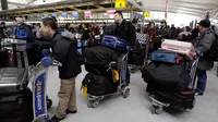 Para penumpang menunggu penerbangan yang tertunda di Terminal 4 Bandara Internasional John F Kennedy (JFK), New York, Senin (8/1). Sebelumnya, bandara mengalami rentetan penundaan akibat suhu ekstrem yang terjadi di wilayah timur laut AS (AP/Richard Drew)