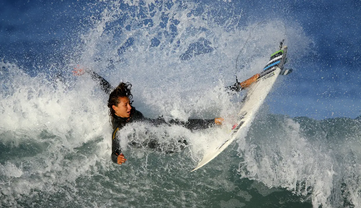 Seorang peselancar putri beraksi di pantai Cardiff, California, AS, (27/10/2015). (Reuters/Mike Blake)