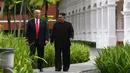 Suasana saat Presiden AS Donald Trump (kiri) dengan Pemimpin Korea Utara Kim Jong-un berjalan di taman Hotel Capella, Pulau Sentosa, Singapura, Selasa (12/6). Trump dan Kim optimis bahwa KTT akan sukses. (Anthony Wallace/Pool/AFP)