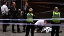 Polisi memeriksa jasad di TKP setelah insiden penikaman di Melbourne, Australia, Jumat (9/11). Kelompok IS mengaku bertanggung jawab atas penyerangan tersebut. (Photo by William WEST/AFP)