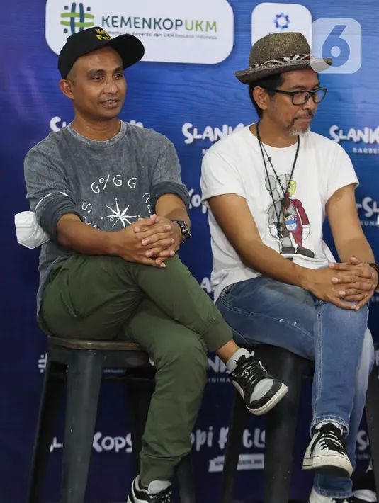 Gitaris grup band Slank Ridho (kanan) bersama bassist Ivan saat peluncuran Slankops di Basecamp Slank, Jakarta, Selasa (19/7/2022). Slank meluncurkan koperasi yang diberi nama Koperasi Konsumen Slank Jurus Tandur atau Slankops. (Liputan6.com/Herman Zakharia)