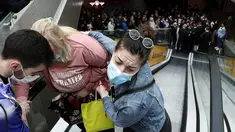 Seorang wanita dibantu naik eskalator saat orang antre vaksinasi dan menjadi salah satu orang yang menerima kupon belanja, di pusat perbelanjaan Usce di Beograd, Kamis (6/5/2021). Pemerintah Serbia menawarkan uang Rp 430 ribu bagi warganya yang divaksinasi sebelum akhir Mei. (AP/Darko Vojinovic)