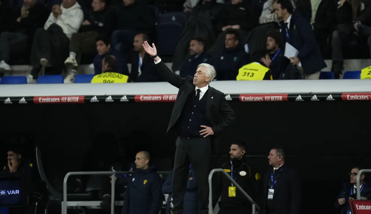 Pelatih Real Madrid, Carlo Ancelotti memberikan instruksi kepada pemainnya saat bertanding melawan Cadiz selama pertandingan lanjutan La Liga Spanyol di stadion Santiago Bernabeu di Madrid, Jumat (11/11/2022). Tambahan tiga poin ini membuat Madrid terus menempel Barcelona di puncak klasemen La Liga. (AP Photo/Manu Fernandez)