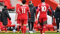 Para pemain Liverpool berjalan lesu ke arah sang pelatih, Jurgen Klopp, setelah takluk 0-1 dari Fulham pada lanjutan Liga Inggris 2020/2021 di Stadion Anfiled, Minggu (7/3/2021). (AFP/Paul Ellis)