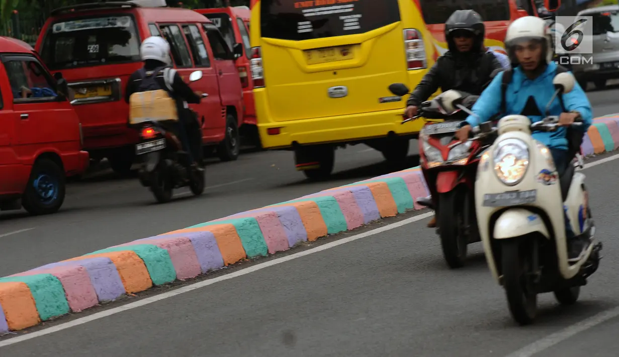 Pengendara melintasi Jalan TB Simatupang, Jakarta, Jumat (7/7). Jalan TB Simatupang sekitar perempatan Pasar Rebo menjadi berwarna dengan tampilan pot cat dan pembatas jalan warna warni. (Liputan6.com/Helmi Fithriansyah)