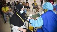 Tenaga kesehatan memeriksa tensi darah sebelum disuntik vaksin Coronavac di Rumah Sakit Darurat Covid-19 Wisma Atlet Kemayoran, Jakarta, Rabu (20/1/2021). Vaksinasi kepada 2.630 tenaga kesehatan menjadi prioritas karena bersinggungan langsung dengan pasien. (Liputan6.com/Fery Pradolo)