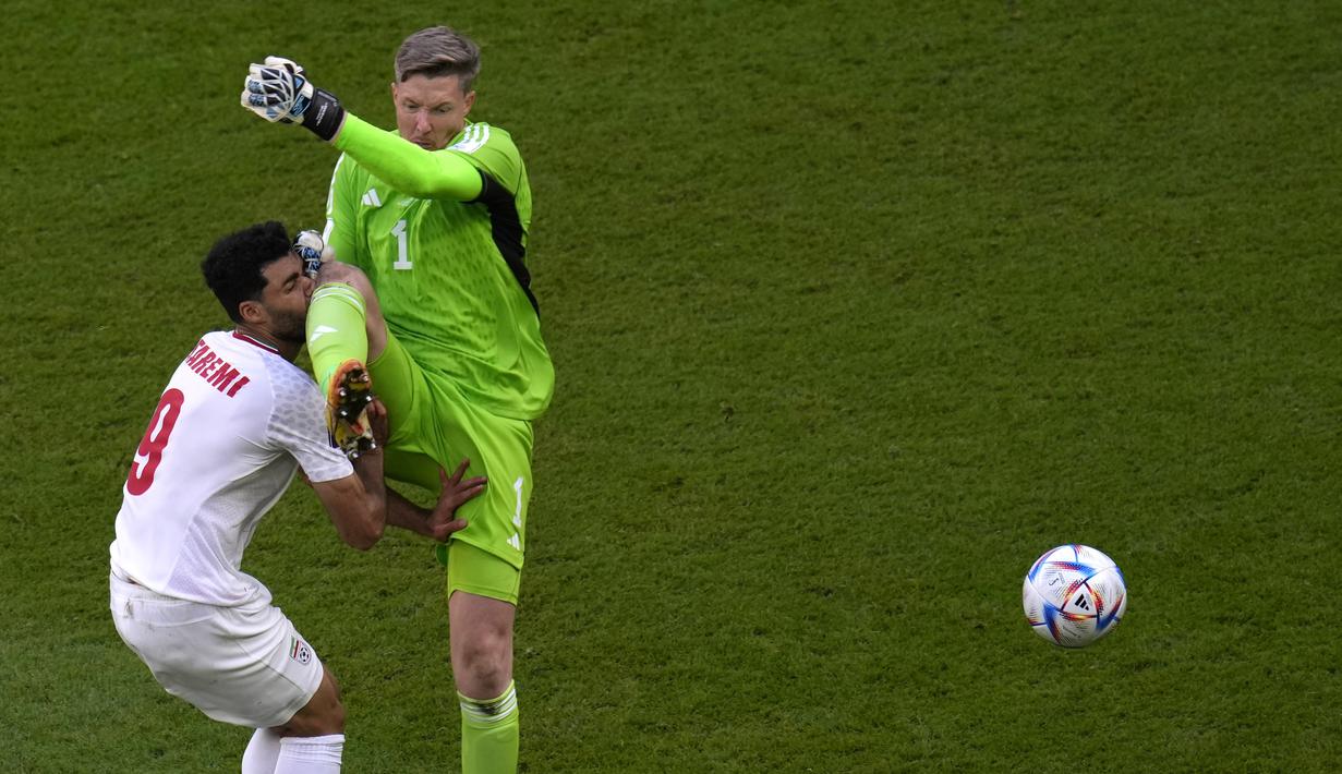 Nasib buruk menimpa Wales usai Wayne Hennessey (kanan) melanggar penyerang Iran, Mehdi Taremi dalam perebutan bola satu melawan satu. (AP Photo/Manu Fernandez)
