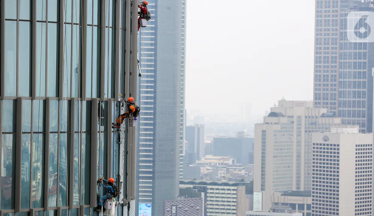 Pekerja membersihkan kaca gedung bertingkat di Jakarta, Jumat (26/02/2021). Berdasarkan data BP Jamsostek kasus kecelakaan kerja di Indonesia menurun 1,46 persen dengan catatan pada tahun 2020 mencapai 153.044 kasus dibandingkan 2019 sebanyak 155.327 kasus. (Liputan6.com/Fery Pradolo)