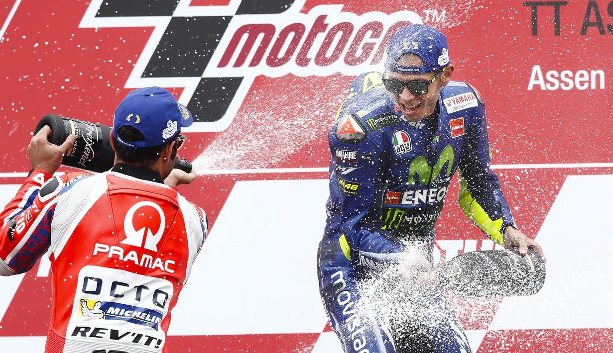 Pebalap Movistar Yamaha, Valentino Rossi, merayakan keberhasilannya menjadi yang tercepat pada MotoGP Belanda di Sirkuit Assen, Assen, Minggu (25/6/2017). Riders asal Italia itu memiliki catatan waktu 41 menit 41,149 detik. (AFP/Vincent Jannink) 