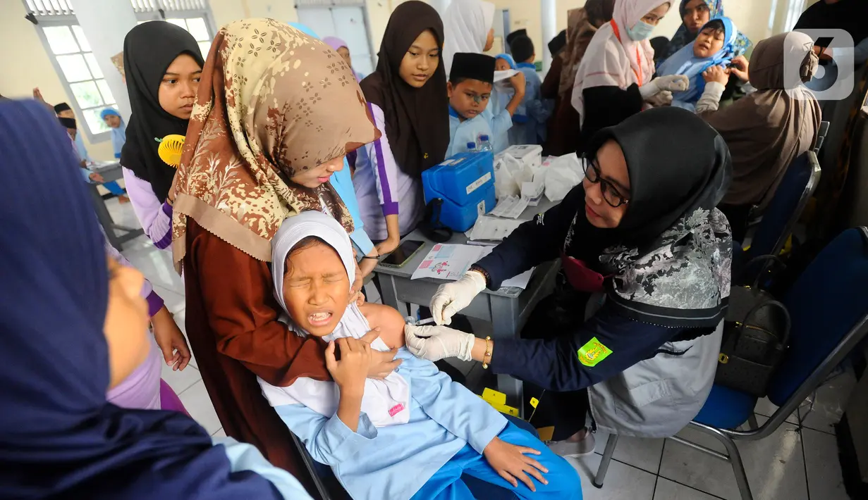 Petugas Puskesmas Cinere saat melakukan pemberian vaksin HPV Nusagard  di SDI Al-Hidayah, Depok, Jawa Barat, Jumat(11/8/2023). (merdeka.com/Arie Basuki)