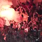 Suporter Persija Jakarta, The Jakmania, menyalakan flare usai mengalahkan Mitra Kukar pada laga Liga 1 di SUGBK, Jakarta, Minggu (9/12). Persija menang 2-1 atas Mitra. (Bola.com/Yoppy Renato)