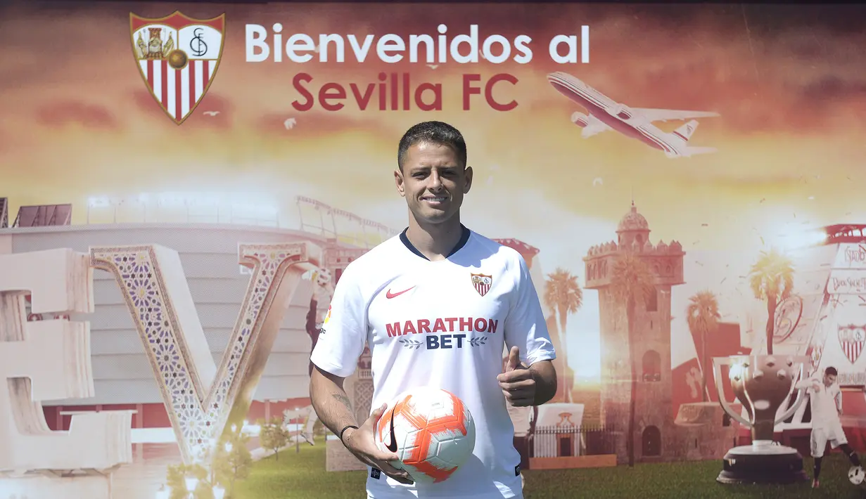 Penyerang baru Sevilla, Javier Hernandez 'Chicharito' berpose dengan jersey klub barunya selama presentasi resminya di Sport City of Sevilla (2/9/2019). Eks penyerang Manchester United dan Real Madrid ini digaet Sevilla dengan mahar yang dikabarkan mencapai 8 juta euro. (AFP Photo/Cristina Quicler)