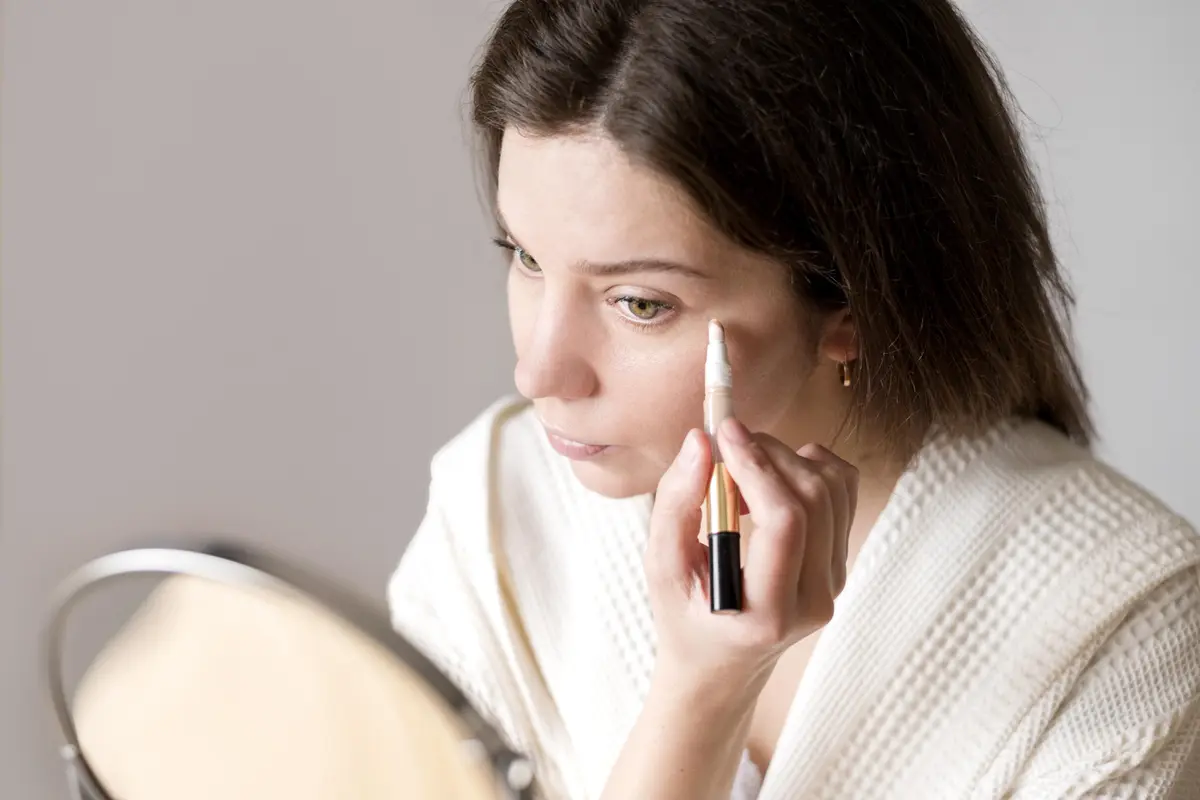 Gunakan concealer full coverage untuk menyamarkan bawah mata yang gelap