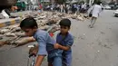 Dua bocah berbonceng sepeda melewati bangkai anjing di kawasan Karachi, Pakistan, Kamis (4/8). Pemerintah setempat terpaksa melakukan pembinasaan tersebut dengan alasan jumlah anjing liar yang terus meningkat. (REUTERS/Akhtar Soomro)