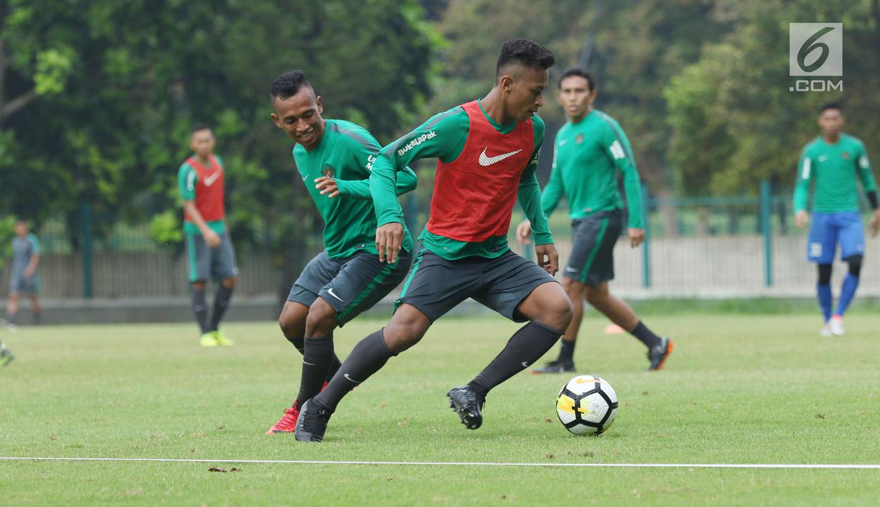 Pemain Timnas Indonesia U-23, Irfan Jaya (kiri) berebut bola dengan Osvaldo Haay saat latihan di Lapangan A Senayan, Jakarta, Sabtu (17/3). Latihan ini persiapan uji tanding melawan Singapura pada 21 Maret mendatang. (Liputan6.com/Helmi Fithriansyah)