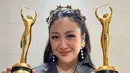 Sherina Munaf berhasil meraih dua piala sekaligus. Di momen itu, ia tampil vest selempang hitam dengan detail bordir emas karya TANGAN Privé, yang dipadukan dengan rok tenun berwarna merah. Penampilannya tampak elegan dan khas dengan sentuhan budaya Indonesia. [@sherinamunaf].