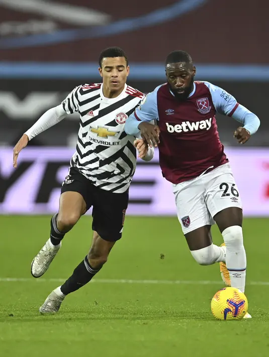 Pemain West Ham, Arthur Masuaku membawa bola dari kejaran gelandang Manchester United, Mason Greenwood pada pertandingan lanjutan Liga Inggris di stadion London di London, Inggris, Minggu (6/12/2020). MU menang 3-1 atas West Ham. (Justin Setterfield/Pool Via AP)