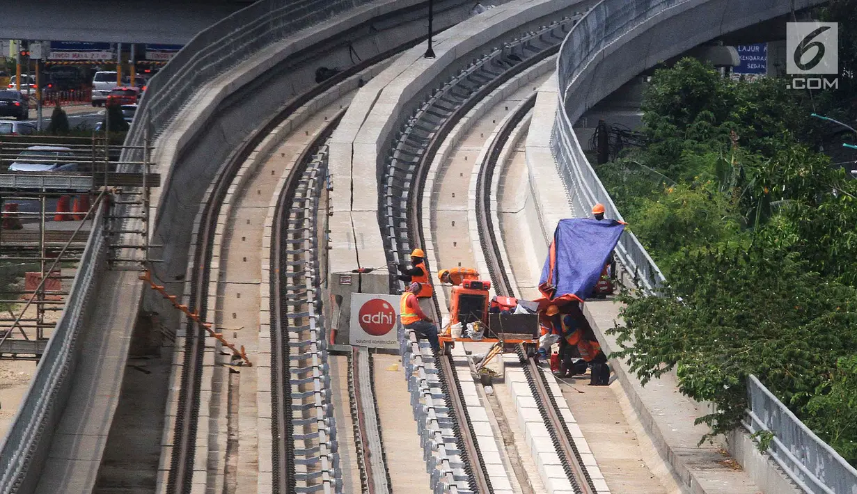 Pekerja menyelesaikan pembangunan LRT (Light Right Transit) Jabodebek di kawasan Kampung Makasar, Jakarta, Sabtu (26/10/2019). LRT akan diuji coba pada awal November 2019. (Liputan6.com/JohanTallo)