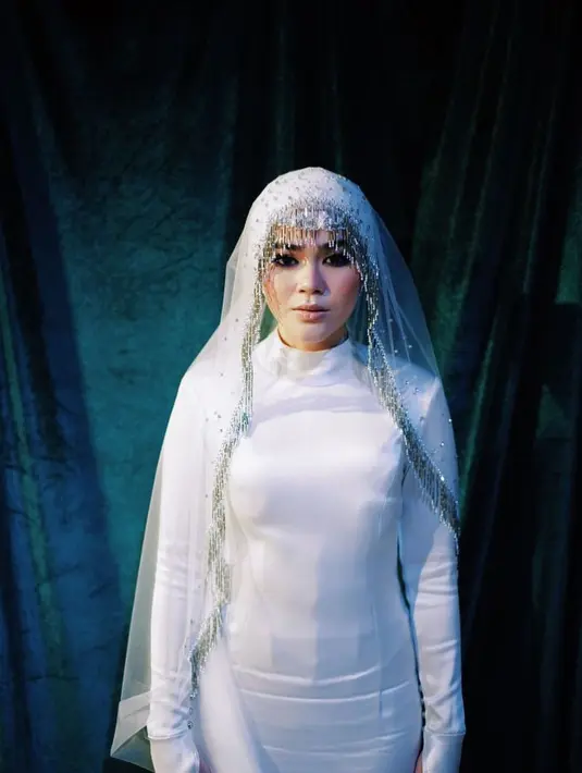 Sivia Azizah memilih white slik gown yang sederhana dipadukan turban dan veil saat resepsi pernikahannya. [Instagram/siviazizah]