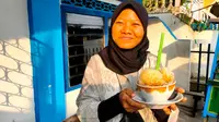Heni Martinez, salah satu pengunjung Festival Lorong Roda menyicipi es kacang yang legendaris di Kota Palembang Sumsel (Liputan6.com / Nefri Inge)
