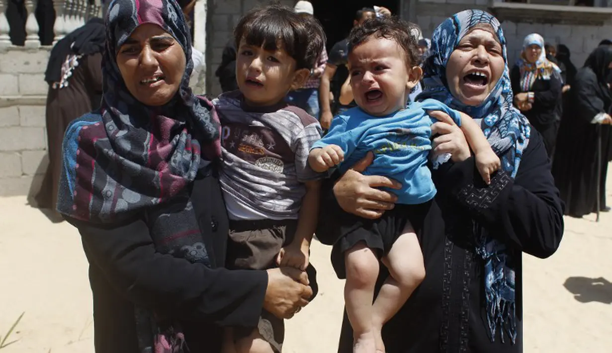 Dua orang Ibu beserta anaknya menangis saat mengetahui anggota keluarganya meninggal akibat serangan udara Israel(14/07/2014) (AFP PHOTO/SAID KHATIB)