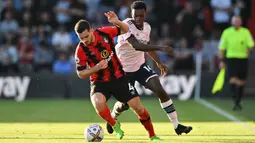 Pemain Bournemouth Lewis Cook (depan) berebut bola dengan pemain Arsenal Eddie Nketiah (belakang) pada pertandingan sepak bola Liga Premier Inggris di Stadion Vitality, Bournemouth, Inggris, 20 Agustus 2022. Arsenal menang 3-0. (Glyn KIRK/AFP)