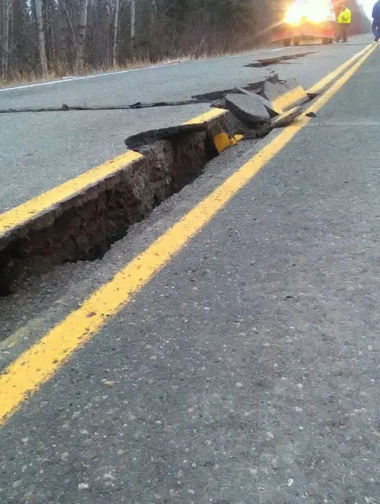 Retakan jalan menyusul gempa bumi di Kenai Spur Highway di Kenai, Alaska, Jumat (30/11). Gempa bermagnitudo 7.0 dan 5.7 menghancurkan jalan raya dan gedung-gedung serta memicu peringatan gelombang tsunami. (Caroline Huber / HANDOUT Caroline Huber / AFP)