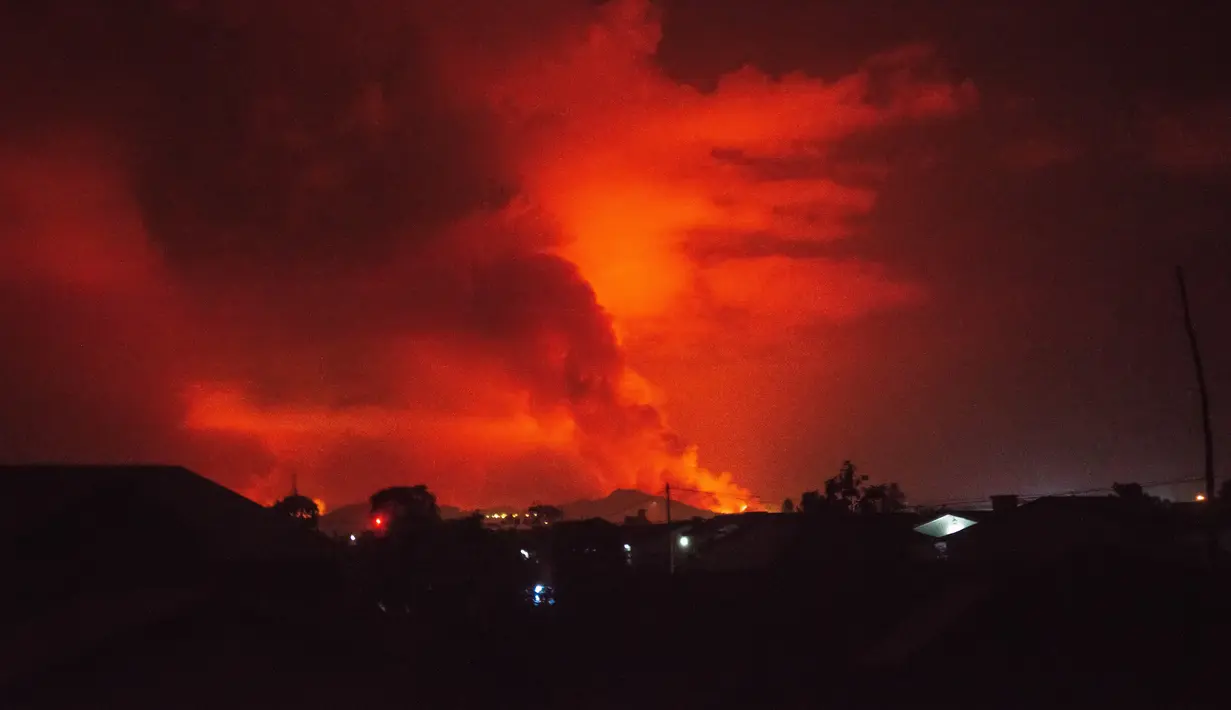 Pandangan umum pada 22 Mei 2021 di Goma di sebelah timur Republik Demokratik Kongo ini menunjukkan api yang menyembur dari gunung berapi Nyiragongo. Kilauan erupsi Gunung Nyiragongo mewarnai merah langit malam di atas kota tepi danau berpenduduk sekitar 2 juta jiwa tersebut. (Moses Sawasawa/AFP)