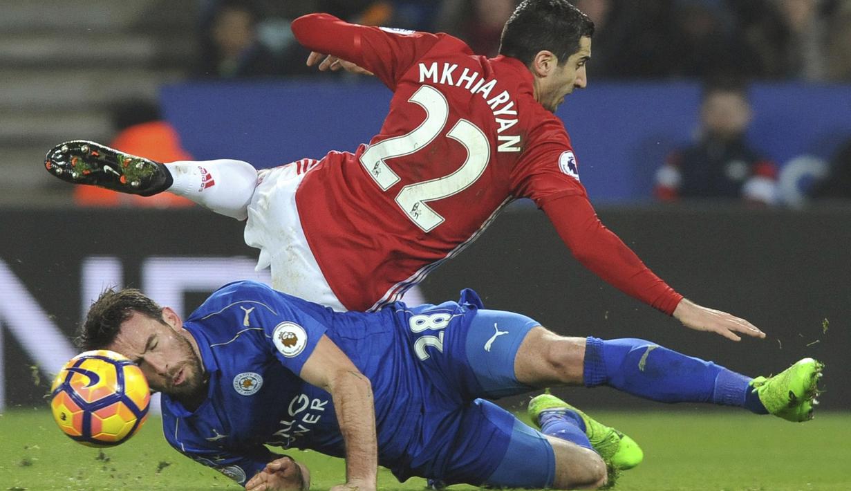 Pemain Manchester United, Henrikh Mkhitaryan (atas) terjatuh saat berebut bola dengan pemain Leicester City, Christian Fuchs pada lanjutan Premier League pekan ke-24 di King Power Stadium, Leicester, (5/2/2017).  MU menang 3-0. (AP/Rui Vieira)