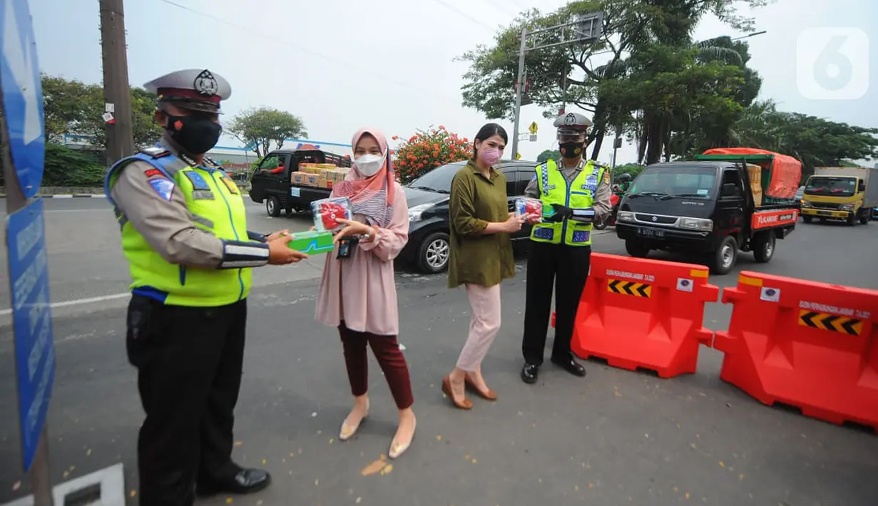 Pegawai BTN membagikan makanan dan hand sanitizer kepada petugas yang menjaga area penyekatan di kawasan Samsat Daan Mogot, Jakarta, Kamis (22/07/2021). BTN telah menyalurkan dana Bansos dalam meringankan beban rakyat terdampak pandemi Covid-19. (Liputan6.com) 