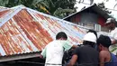 Sejumlah orang mengeluarkan motor dari rumah yang rusak akibat gempa di Ambon, Maluku, Jumat (27/9/2019). Badan Nasional Penanggulangan Bencana (BNPB) mengatakan 171 rumah rusak akibat gempa Magnitudo 6,5 yang mengguncang Maluku pada 26 September 2019. (HO/BADAN NASIONAL PENANGGULANGAN BENCANA/AFP)