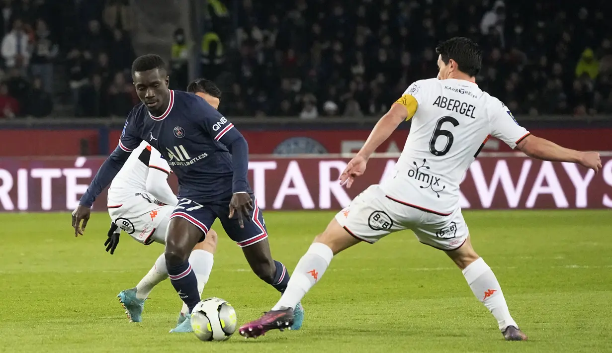 Gelandang PSG, Idrissa Gueye berusaha melewati pemain Lorient, Laurent Abergel pada pertandingan lanjutan Liga 1 Prancis di stadion Parc des Princes di Paris, Senin (4/4/2022). Hasil ini membuat PSG mengumpulkan 68 poin dari 30 pertandingan. (AP Photo/Michel Euler)