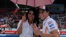 Marc Marquez (kiri) berpose bersama salah satu gadis payung saat berlangsungnya acara Meet & Greet di Sirkuit Sentul, Bogor, (21/10/2014). (Liputan6.com/Helmi Fithriansyah)