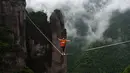 Seorang peserta berjalan diatas tali untuk menyebrangi tebing tinggi di Provinsi Zhejiang , China , 7 Mei 2016. Ini merupakan sebuah pertunjukan yang dilakukan di Taizhou. (China Daily /REUTERS)