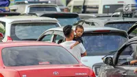 Pemudik bersama anaknya saat menanti waktu masuk kapal penyebrangan di Dermaga 1 Pelabuhan Penyebrangan Merak, Banten, Sabtu (1/6/2019). (Liputan6.com/Helmi Fithriansyah)