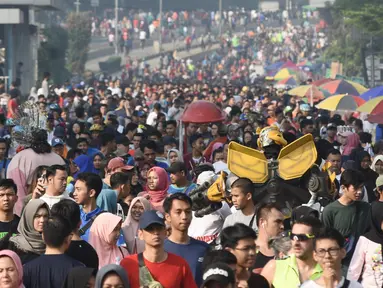 Warga berolahraga saat Car Free Day di Jalan MH Thamrin, Jakarta, Minggu (16/6/2019). Pemprov DKI Jakarta kembali memberlakukan HBKB atau car free day di Jalan MH Thamrin dan Jalan Jenderal Sudirman pascalibur lebaran setiap hari Minggu mulai pukul 06.00 - 11.00 WIB. (Liputan6.com/Angga Yuniar)