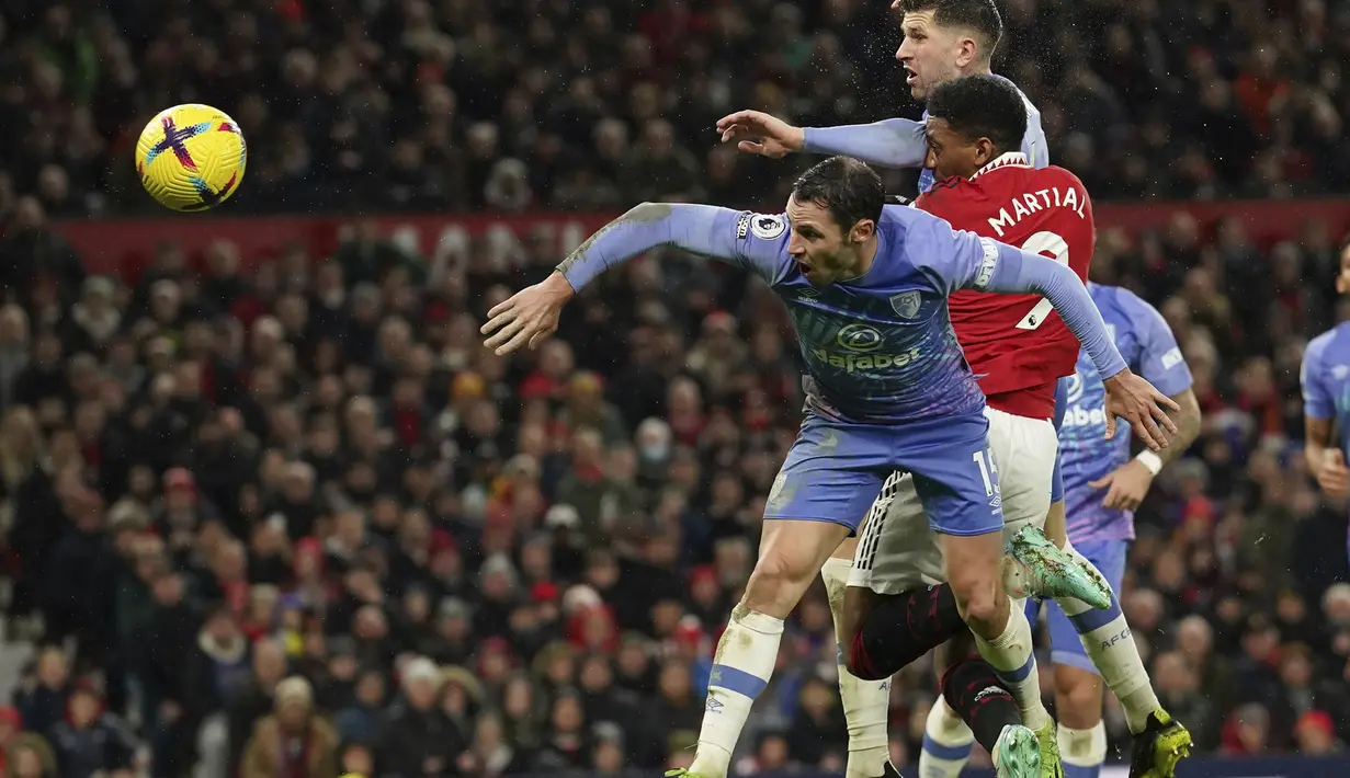 Penyerang Manchester United, Anthony Martial menyundul bola dari kawalan dua pemain Bournemouth pada pertandingan lanjutan Liga Inggris di Old Trafford di Manchester, Inggris, Rabu (4/1/2023). Bournemouth tertahan di posisi ke-15 dengan 16 poin. (AP Photo/Dave Thompson)