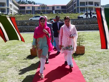 Aktivis Pakistan dan penerima Nobel Perdamaian Malala Yousafzai (kiri) didampingi Menteri Negara untuk Informasi dan Penyiaran Pakistan, Maryam Aurangzeb saat tiba di kampung halamannya di Kota Swat, Pakistan (31/3). (AFP Photo/Abdul Majeed)