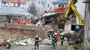 Alat berat dikerahkan untuk mencari korban di reruntuhan sebuah apartemen tua yang ambruk di Swiebodzce, Polandia, Sabtu (8/4). Akibat insiden itu, 5 orang dikabarkan tewas, 2 di antaranya adalah anak-anak. (Natalia DOBRYSZYCKA/AFP)