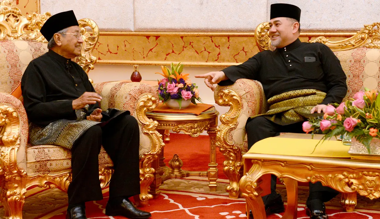 Perdana Menteri Malaysia baru, Mahathir Mohamad (kiri) berbincang dengan dengan Raja Malaysia Muhammad V usai melakukan sumpah jabatan di Istana Nasional di Kuala Lumpur (10/5). (AFP Photo/ Istana Nasional Malaysia)