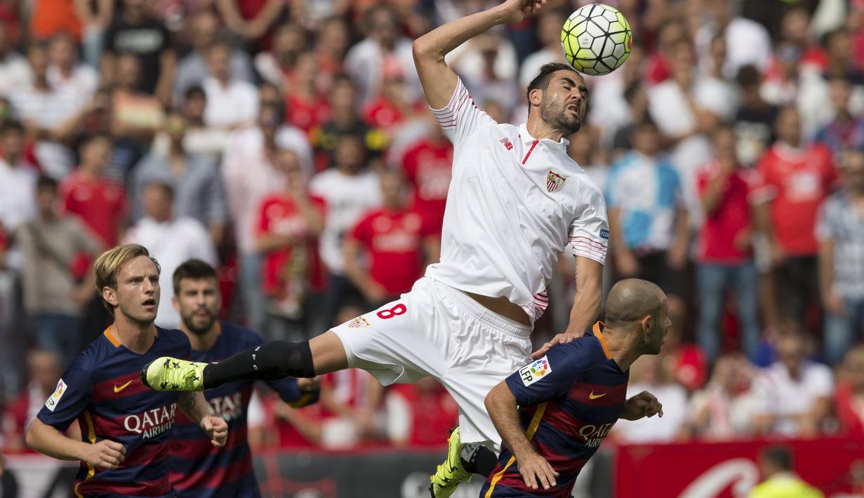 Pemain Sevilla Vicente Iborra (atas) berebut bola dengan pemain Barcelona Javier Mascherano pada laga Liga Spanyol Sevilla FC vs Barcelona di Stadion Ramon Sanchez Pizjuan, Sevilla, Sabtu (3/10/2015). Sevilla menang 2-1.   REUTERS/Marcelo del Pozo